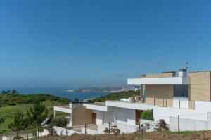 ナザレにあるCasas da Pescaria Aの海を背景にした丘の上の家