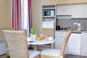 a kitchen with a table and chairs in a kitchen at Résidence de Tourisme Vacances Bleues Villa Regina in Arcachon