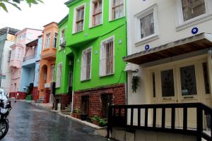 een groen gebouw in een regenachtige straat bij Hotel Megaron in Istanbul