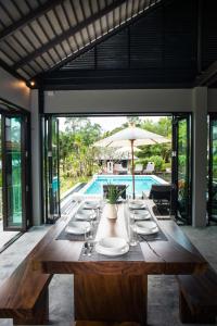 a dining room with a table and a pool at villa inspiration in Ko Chang