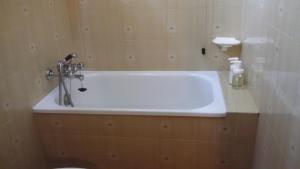 ein Badezimmer mit einer Badewanne und einem Waschbecken in der Unterkunft Adamello in Aprica