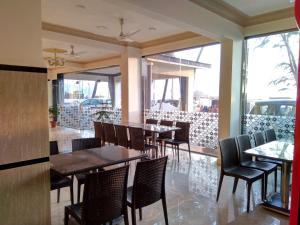 a dining room with tables and chairs in a restaurant at Hotel Murud Marina in Murud