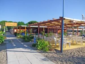 a restaurant with white tables and chairs under a roof at Regina sul Mare in Terracina