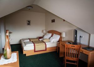 een slaapkamer met een bed en een bureau met een televisie bij Guesthouse Tulipan in Lesce