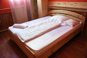 Cama de madera en habitación de madera en Kispipa Panzió en Szombathely