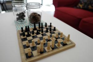 a chess board on a white table with a couch at Norn Yaowarat Hotel in Bangkok
