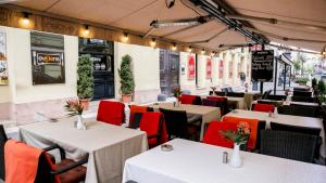ブダペストにあるFirst Budhapest Central Flatの白いテーブルと赤い椅子が備わるレストラン