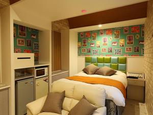 a bedroom with a bed and a couch in it at ホテル マリオン 鈴鹿 in Suzuka