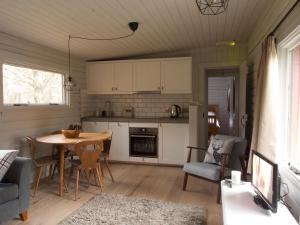 a kitchen with a table and chairs in a room at Woodside Logcabin Ardoch Lodge in Strathyre