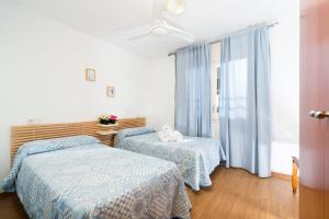 a bedroom with two beds and a window at Apartaments Els Llorers in Lloret de Mar