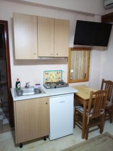 a small kitchen with a sink and a table at Dimitra Pentaliou Rooms in Kamena Vourla