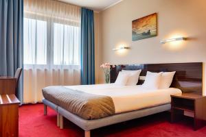 a hotel room with a large bed and a window at Focus Hotel Gdańsk in Gdańsk