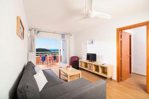 a living room with a couch and a television at Apartaments Els Llorers in Lloret de Mar