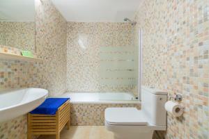 a bathroom with a tub and a toilet and a sink at Apartaments Els Llorers in Lloret de Mar