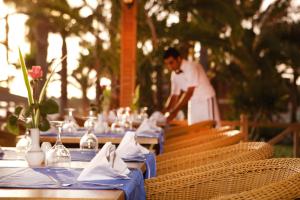 un uomo in piedi davanti a un tavolo con una tovaglia blu di Meryan Hotel - Ultra All Inclusive a Okurcalar