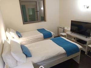 a hotel room with two beds and a flat screen tv at YingYing Apartamento with a free parking space in Lisbon