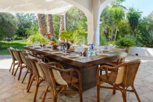 a large wooden table with chairs on a patio at New! Villa Can Colomaret Carmen in Santa Eularia des Riu