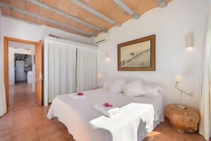 a bedroom with a white bed with two tables at New! Villa Can Colomaret Carmen in Santa Eularia des Riu +38 photos