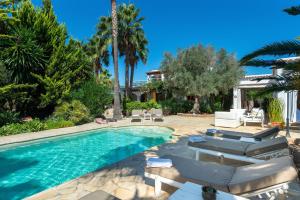 a swimming pool with lounge chairs and a house at New! Villa Can Colomaret Carmen in Santa Eularia des Riu