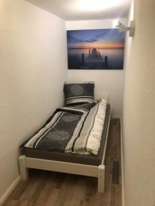 a small bed in a room with a painting on the wall at Monteurzimmer Rodenbach in Rodenbach