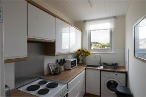 a small kitchen with a stove and a sink at Quiet, Convenient, Hawick Flat in Hawick