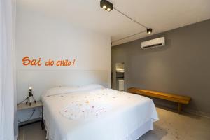 ein Schlafzimmer mit einem weißen Bett und einem Schild an der Wand in der Unterkunft Villa Amado in Morro de São Paulo
