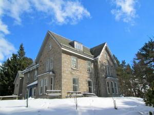 a large brick building with snow on the ground at Braemar Youth Hostel in Braemar