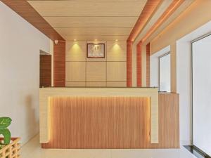 Habitación con paneles de madera y recepción. en Treebo Trend Goodland Residency en Thiruvananthapuram