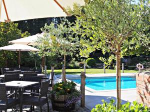Eine Terrasse mit Tischen und Stühlen neben einem Pool in der Unterkunft Stocks Hotel in Sark