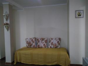 a room with a chair with a yellow blanket at ZUHAUSE in Puerto Iguazú