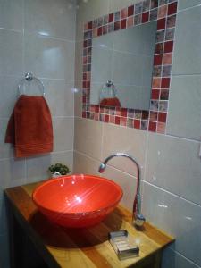 baño con lavabo rojo y espejo en ZUHAUSE en Puerto Iguazú
