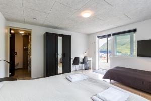 1 dormitorio con cama y vistas al océano en Gjaargardur Guesthouse Gjogv, en Við Gjógv