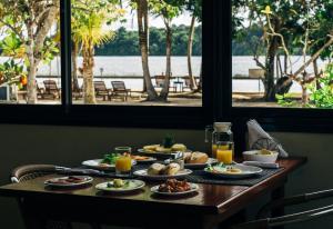 Overbridge River Resort في باراماريبو: طاولة عليها أطباق من المواد الغذائية والمشروبات