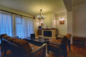 a living room with a couch and a table and a fireplace at Elatos Guest House in Eptalofos