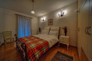 um quarto com uma cama, uma cadeira e uma janela em Elatos Guest House em Eptalofos