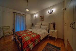 a bedroom with a bed and a chair and a window at Elatos Guest House in Eptalofos