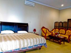 um quarto com uma cama, uma mesa e cadeiras em Nirwana Buton Villa em Baubau