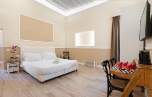 biała sypialnia z białym łóżkiem i telewizorem w obiekcie Residenza D'Epoca La Basilica we Florencji