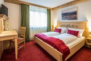 a bedroom with a large bed with a desk and a desk at Hotel - Landgasthof Rebstock in Nimburg