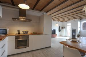 a kitchen with white cabinets and a table and a dining room at VENT DEL NORD in Toses