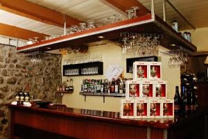 a bar with bottles of alcohol on the wall at Auberge Le Romarin in Valgorge
