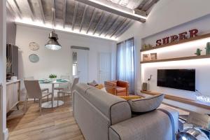sala de estar con sofá y comedor en Mamo Florence - Parione Roof Terrace, en Florencia