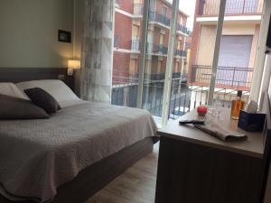 een slaapkamer met een bed en een groot raam bij Camomilla B&B in Alba