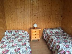 um quarto com 2 camas e uma mesa com um candeeiro em Camping Laciana Natura em Villablino