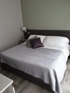 een slaapkamer met een groot bed met witte kussens bij Camomilla B&B in Alba +8 foto's