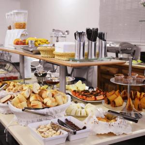 a buffet with many different types of food on a table at Hotel Village Campinas in Campinas