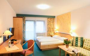 a hotel room with a bed and a desk at Hotel Gasthof zum Biber in Motten