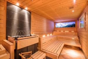 uma sauna de madeira com dois bancos e uma televisão em Hotel DreiSonnen em Serfaus