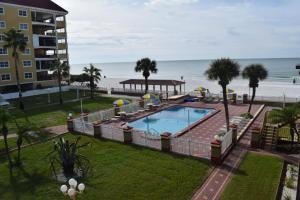 a swimming pool with a gazebo and the beach at Sails Resort Motel in St. Pete Beach