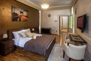 a bedroom with a bed and a desk and a television at Knez Mihailova Apartman in Belgrade